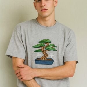 Man wearing a men's grey embroidered oversized t-shirt with a bonsai tree design.