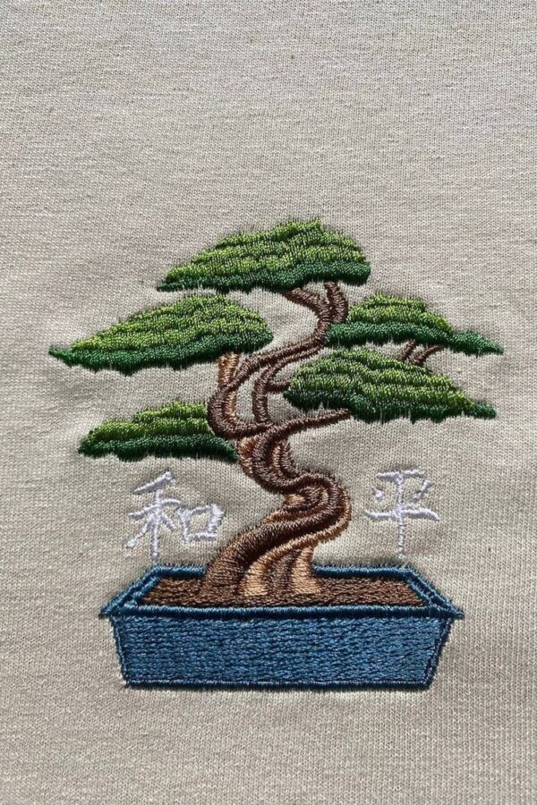 Man wearing a men's grey embroidered oversized t-shirt with a bonsai tree design.