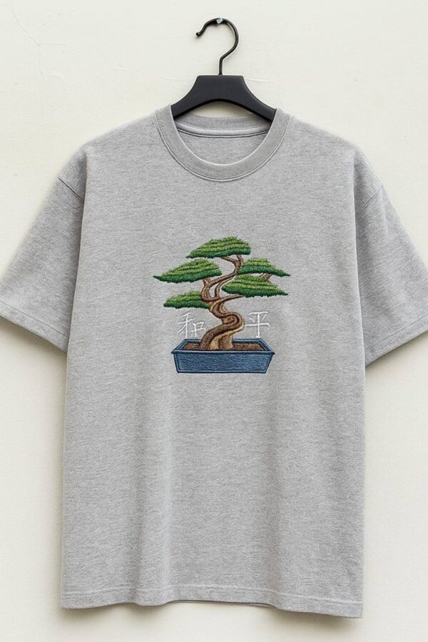 Man wearing a men's grey embroidered oversized t-shirt with a bonsai tree design.